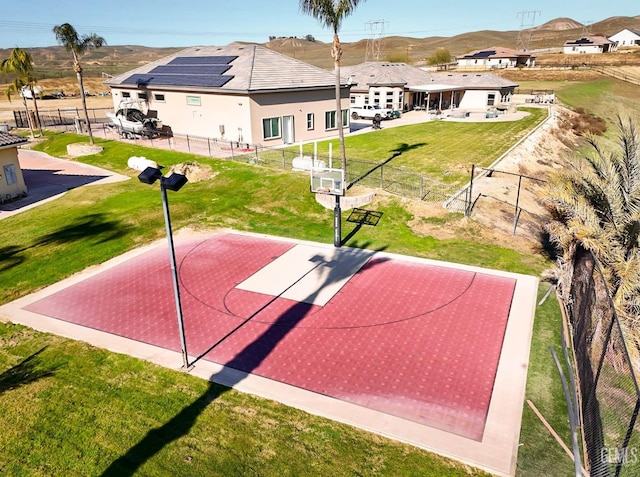 view of sport court with a mountain view and a yard