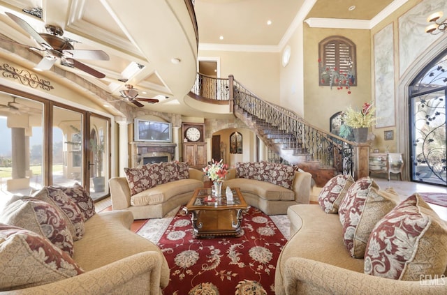 living room with ceiling fan, beam ceiling, a high ceiling, crown molding, and coffered ceiling