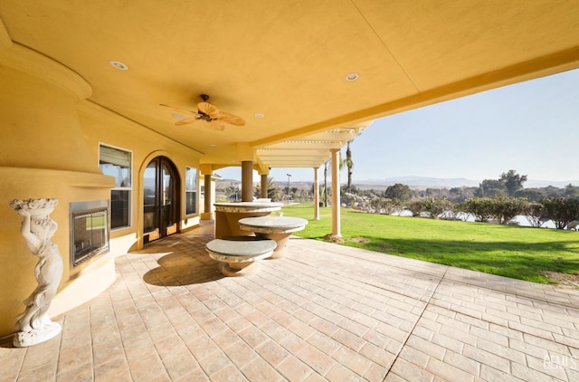 view of patio / terrace with ceiling fan and a mountain view