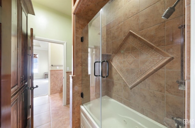 bathroom with tile patterned flooring, tile walls, and shower / bath combination with glass door