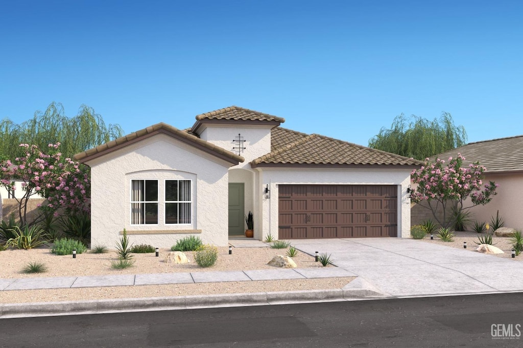 mediterranean / spanish-style house featuring stucco siding, a garage, concrete driveway, and a tile roof