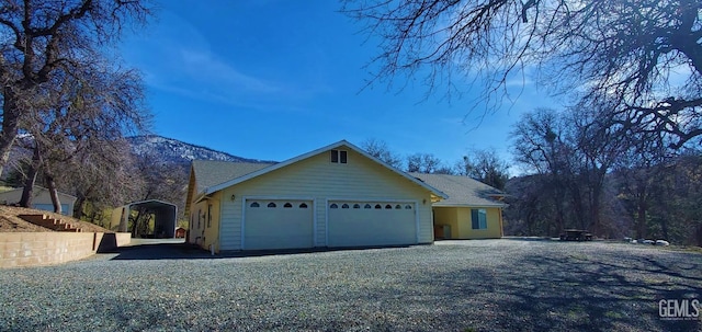 ranch-style house with a mountain view, a carport, and a garage