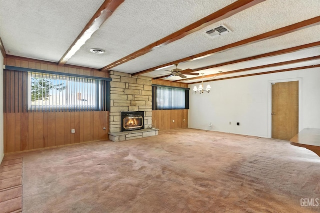 700 Mulberry St, Tehachapi, CA 93561 - unfurnished living room with a textured ceiling, wood walls, beam ceiling, a chandelier, and a stone fireplace