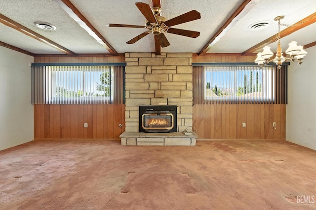 700 Mulberry St, Tehachapi, CA 93561 - unfurnished living room with beamed ceiling, healthy amount of natural light, wood walls, a textured ceiling, and a stone fireplace