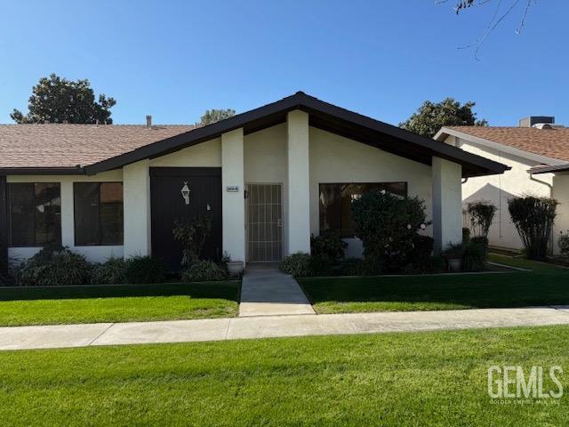 view of front of home featuring stucco siding and a front yard