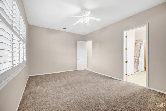 unfurnished bedroom with light carpet, connected bathroom, and ceiling fan