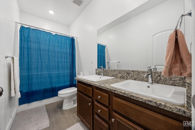 full bathroom with double vanity, shower / bath combo, visible vents, and a sink