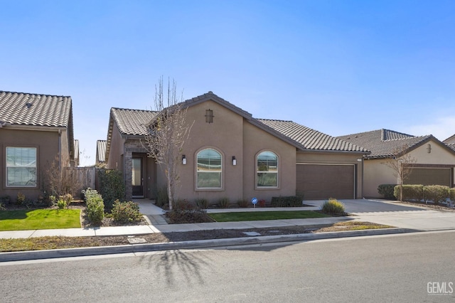 mediterranean / spanish home featuring a garage, driveway, a tile roof, and stucco siding