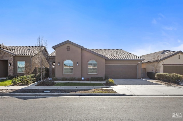 view of front of house with a tile roof, driveway, an attached garage, and stucco siding