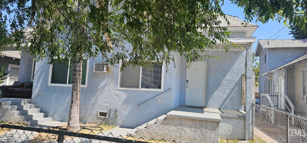 1822 Maple St, Bakersfield, CA 93304 - view of front of home featuring stucco siding, a fenced front yard, and roof with shingles