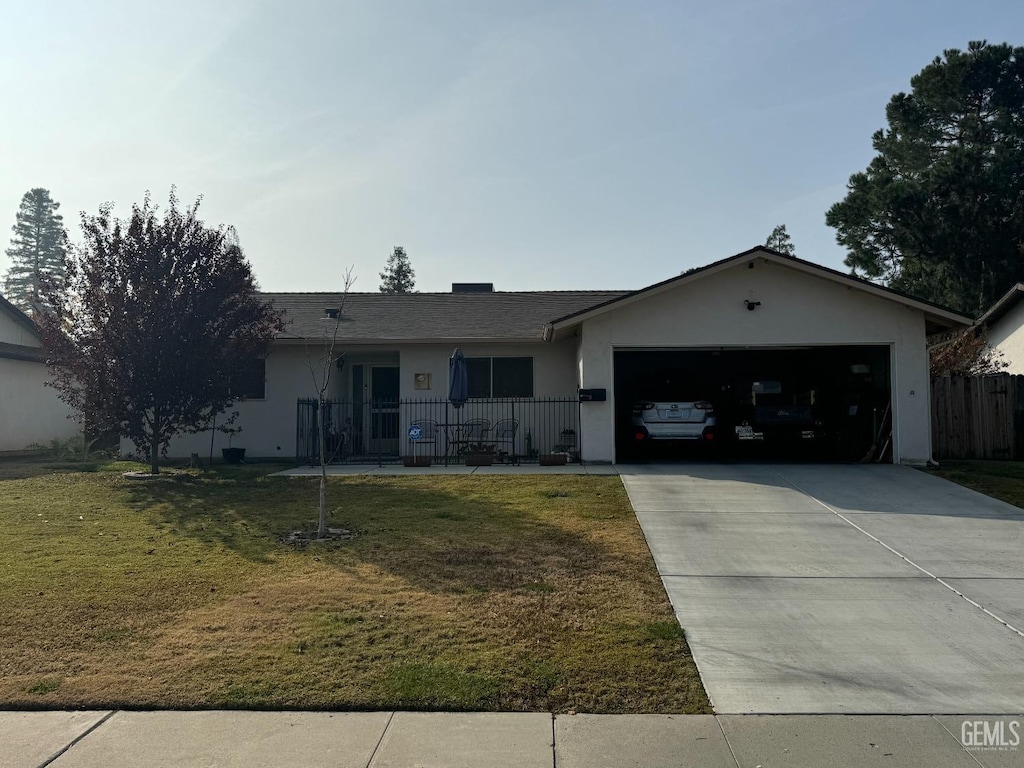 ranch-style house featuring covered porch, a garage, and a front lawn