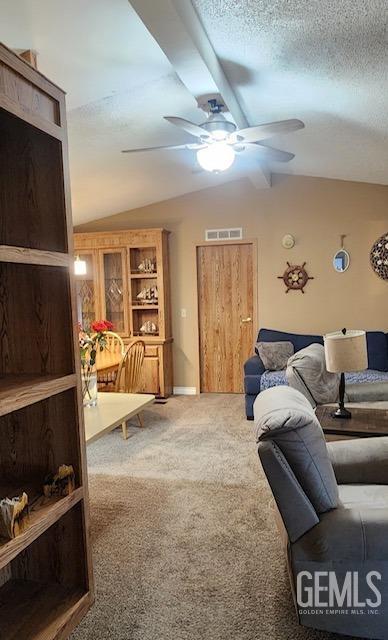 living room featuring a textured ceiling, built in features, carpet, and vaulted ceiling