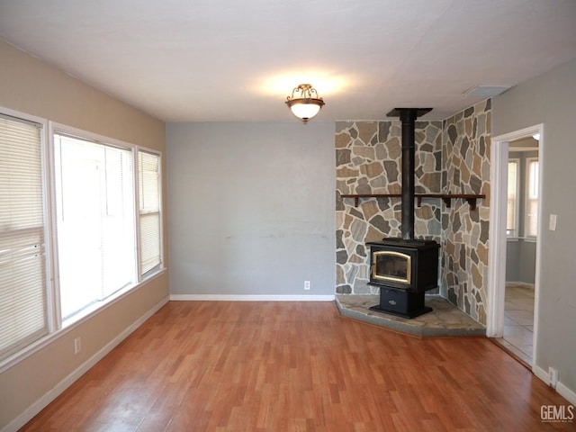 101 Oakdale Dr, Bakersfield, CA 93309 - unfurnished living room with plenty of natural light, wood finished floors, baseboards, and a wood stove