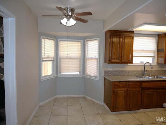 101 Oakdale Dr, Bakersfield, CA 93309 - kitchen featuring a sink, ceiling fan, light tile patterned floors, baseboards, and brown cabinets