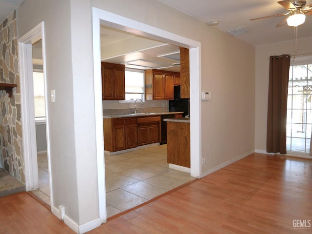 101 Oakdale Dr, Bakersfield, CA 93309 - kitchen featuring brown cabinets, ceiling fan, light wood-type flooring, and black dishwasher