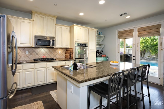 9900 Swansboro Way, Bakersfield, CA 93314 - kitchen featuring appliances with stainless steel finishes, cream cabinetry, recessed lighting, backsplash, and a center island
