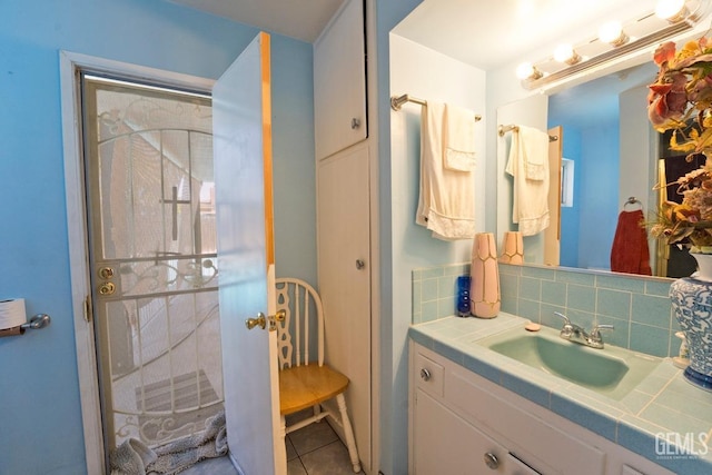 bathroom featuring tasteful backsplash, tile patterned flooring, and vanity