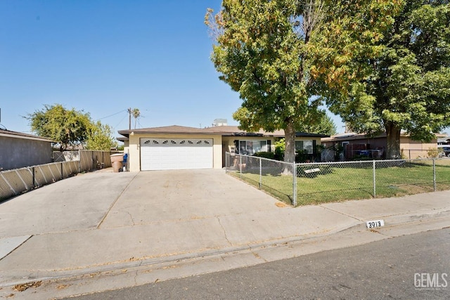 ranch-style house with a garage, fence private yard, driveway, and a front lawn