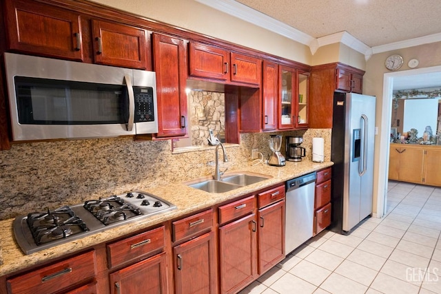 kitchen featuring crown molding, stainless steel appliances, backsplash, glass insert cabinets, and a sink