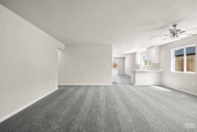707 Poinsettia St, Bakersfield, CA 93307 - unfurnished living room with carpet floors, baseboards, a ceiling fan, recessed lighting, and a sink
