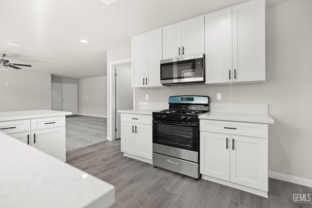 707 Poinsettia St, Bakersfield, CA 93307 - kitchen with stainless steel appliances, light countertops, light wood finished floors, a ceiling fan, and recessed lighting