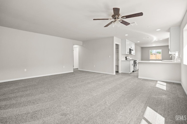 707 Poinsettia St, Bakersfield, CA 93307 - unfurnished living room featuring light colored carpet, a ceiling fan, a sink, recessed lighting, and baseboards