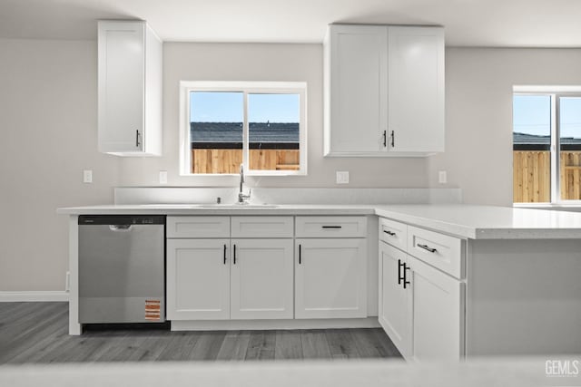 707 Poinsettia St, Bakersfield, CA 93307 - kitchen with dishwasher, a sink, light wood finished floors, and white cabinetry