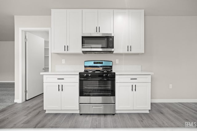 707 Poinsettia St, Bakersfield, CA 93307 - kitchen featuring stainless steel appliances, light wood-style flooring, light countertops, and white cabinets