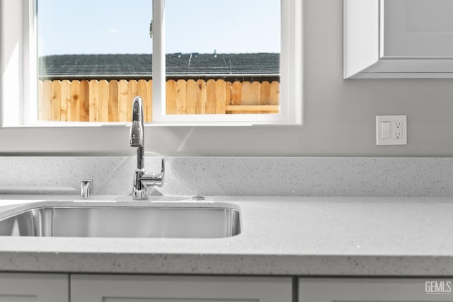 707 Poinsettia St, Bakersfield, CA 93307 - kitchen view of a sink, white cabinets, and light stone countertops