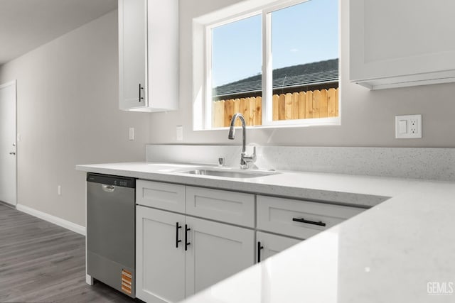 707 Poinsettia St, Bakersfield, CA 93307 - kitchen featuring dishwasher, a sink, white cabinets, wood finished floors, and baseboards