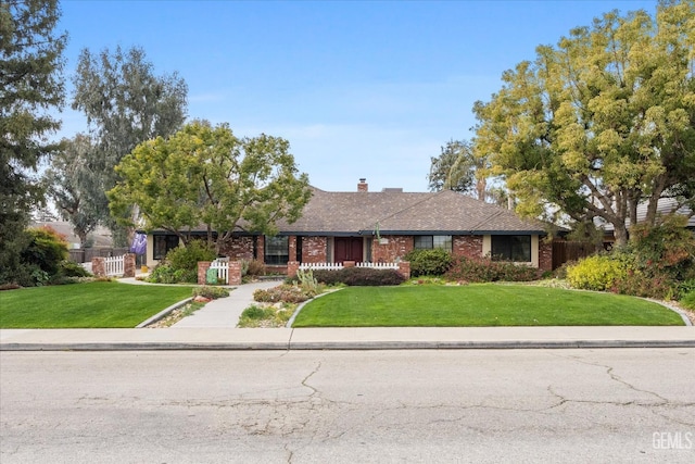 ranch-style house featuring brick siding and a front yard