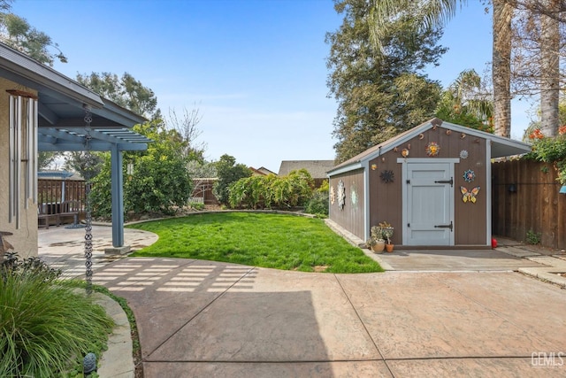 view of yard featuring an outbuilding, a patio area, and a fenced backyard