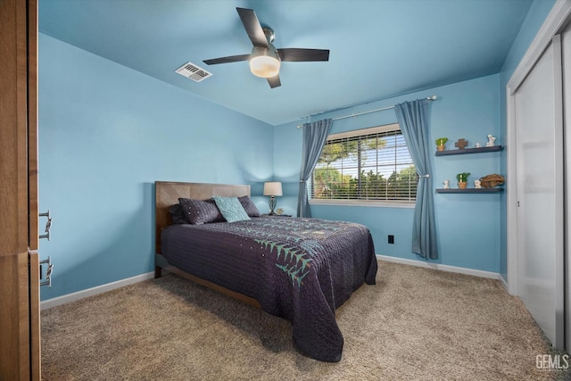 carpeted bedroom featuring a ceiling fan, a closet, visible vents, and baseboards