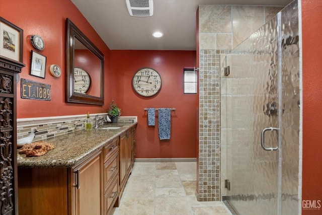 bathroom featuring visible vents, a stall shower, stone finish floor, vanity, and baseboards