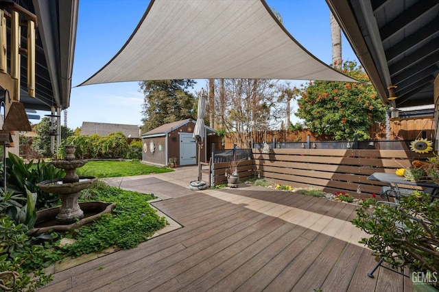 deck featuring an outbuilding, a fenced backyard, and a storage unit