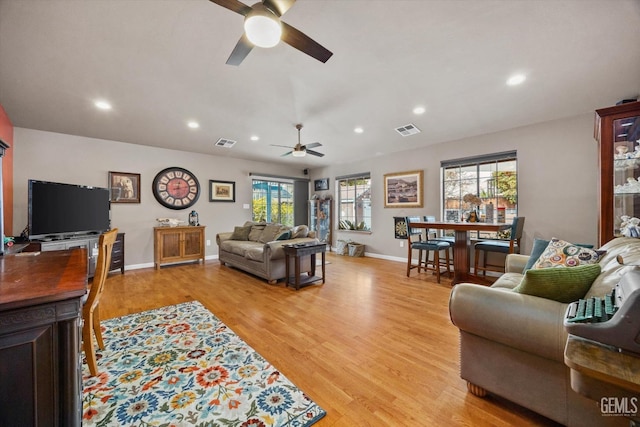 living room featuring light wood-type flooring, baseboards, visible vents, and recessed lighting