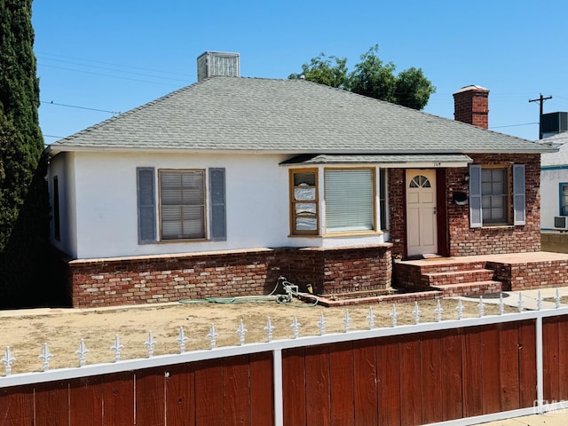 104 E Kern St, Taft, CA 93268 - view of front of house with a chimney, a fenced front yard, and roof with shingles