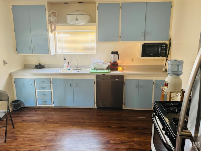 104 E Kern St, Taft, CA 93268 - kitchen featuring stainless steel dishwasher, black microwave, dark wood-type flooring, range with gas stovetop, and a sink
