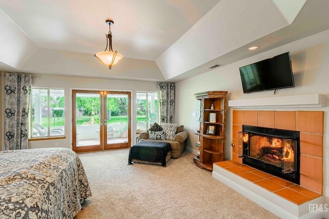 carpeted bedroom with visible vents, a raised ceiling, access to outside, and multiple windows