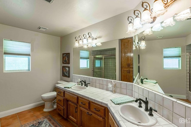 bathroom with visible vents, baseboards, a stall shower, and a sink