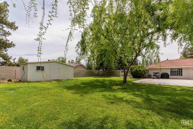 view of yard featuring an outbuilding, a patio, and a fenced backyard