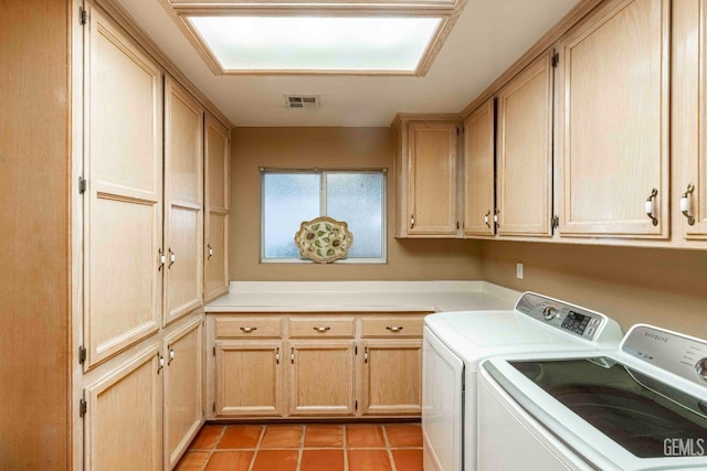 clothes washing area with visible vents, light tile patterned floors, cabinet space, and washer and clothes dryer