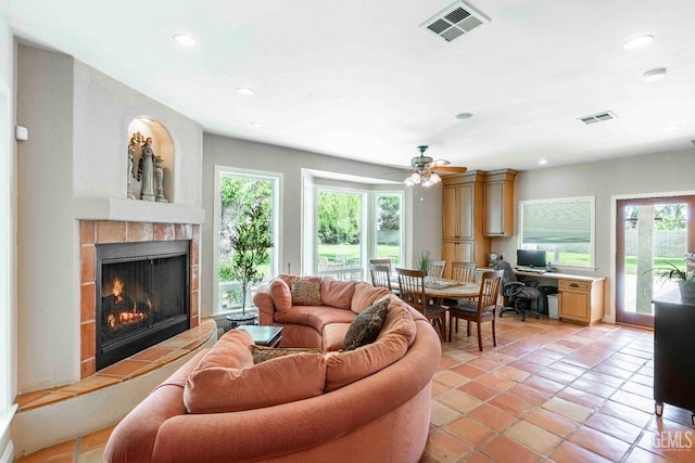 living area featuring visible vents, a fireplace, and plenty of natural light