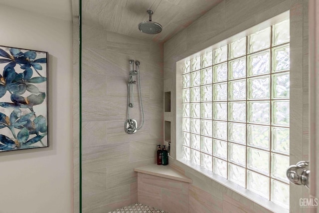 full bathroom with a tile shower and a healthy amount of sunlight