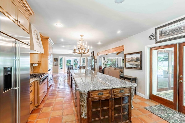 kitchen featuring open floor plan, stainless steel built in refrigerator, recessed lighting, and a chandelier