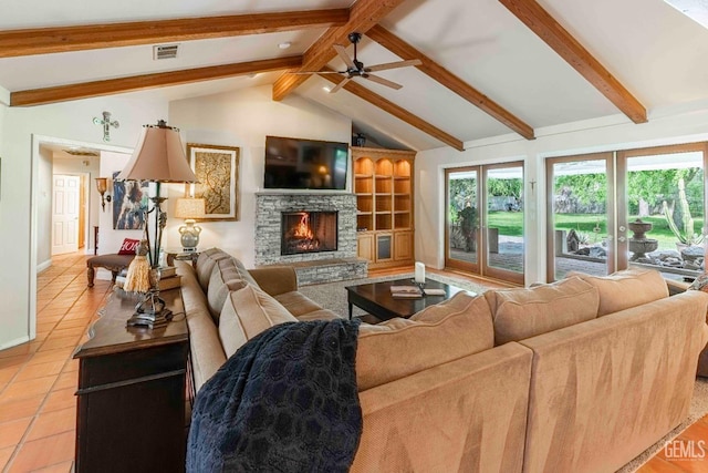 living room with a wealth of natural light, ceiling fan, tile patterned flooring, and vaulted ceiling with beams