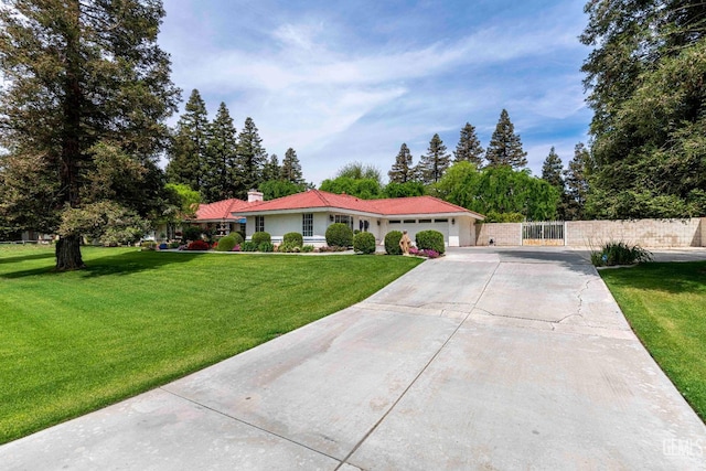 view of front of home featuring a gate, fence, a garage, a front lawn, and concrete driveway