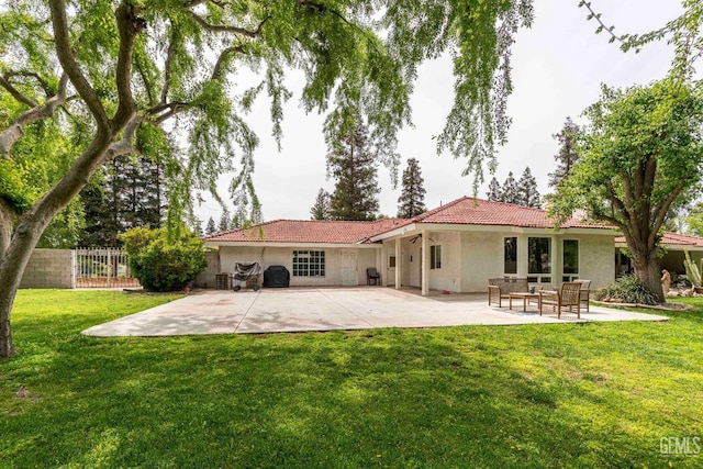 back of house featuring fence, a patio, a tiled roof, stucco siding, and a yard