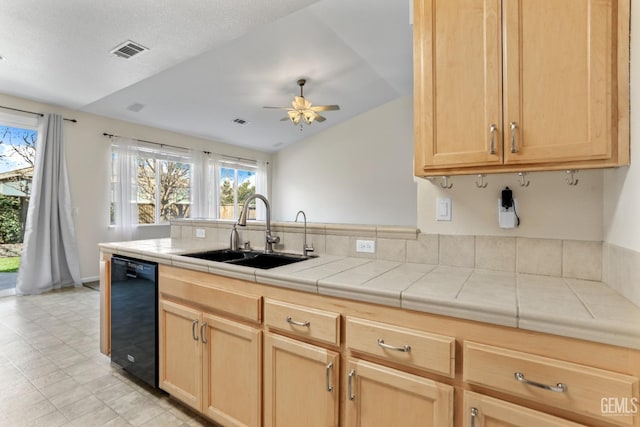 kitchen with sink, ceiling fan, black dishwasher, tile counters, and light brown cabinetry