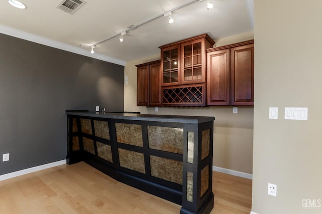 bar featuring crown molding and light hardwood / wood-style floors